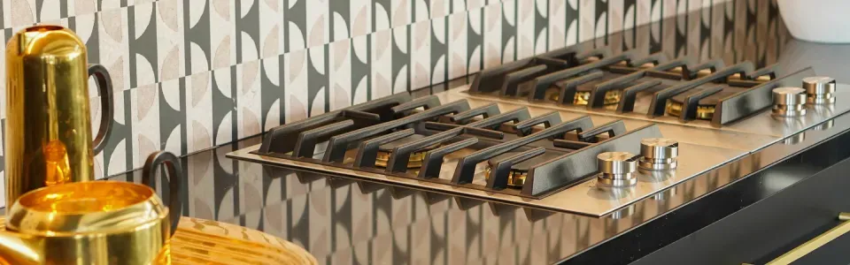 photo of a gas stove in a kitchen with art deco tiles for a backsplash